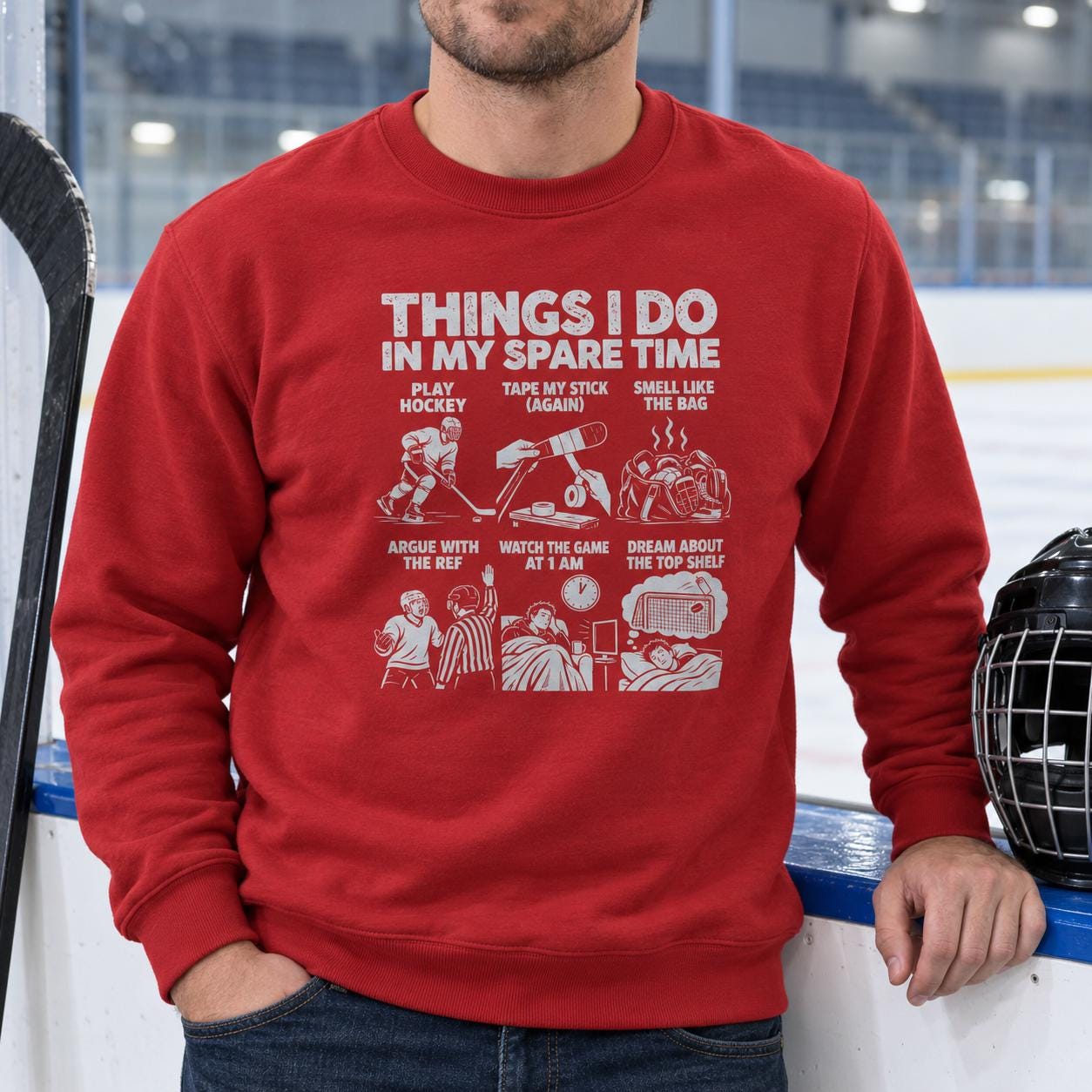 Man in the red hockey spare time sweatshirt sitting by the boards with his helmet