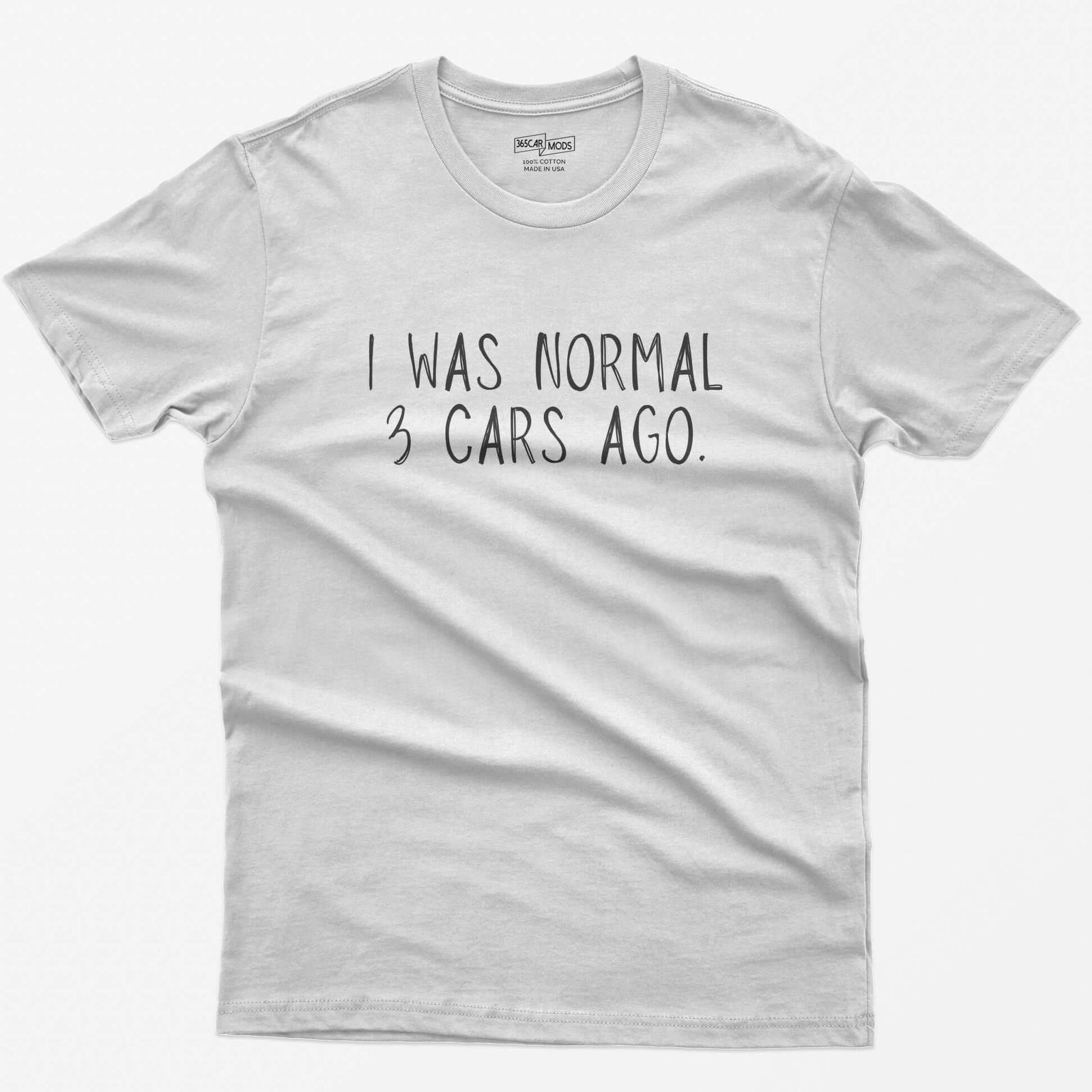 White t-shirt with thin hand-lettered white text reading I Was Normal 3 Cars Ago