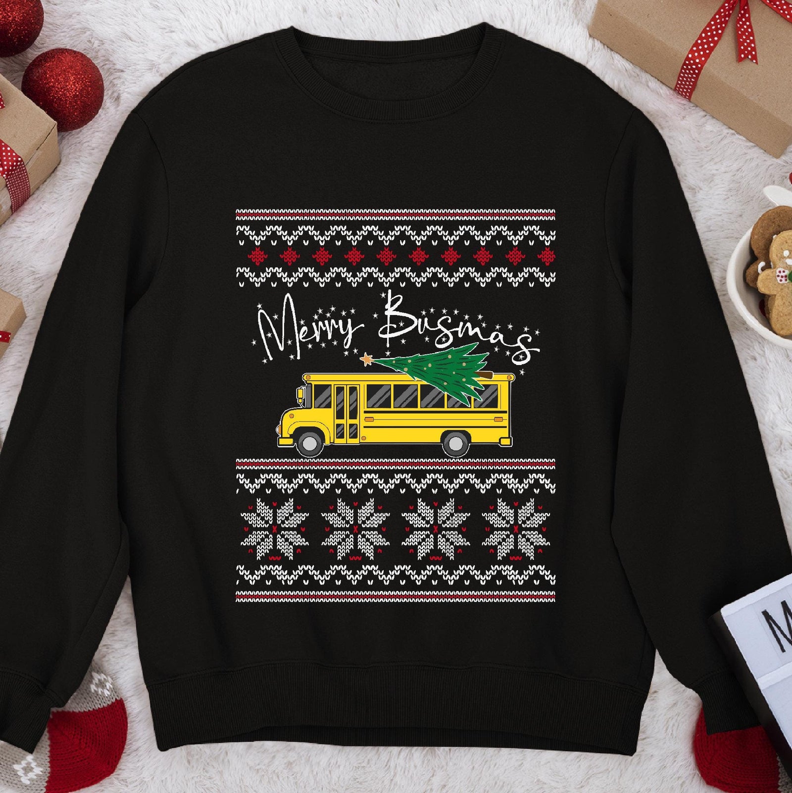 Dark Christmas sweatshirt with a yellow school bus carrying a tree under script Merry Busmas, knit sweater bands