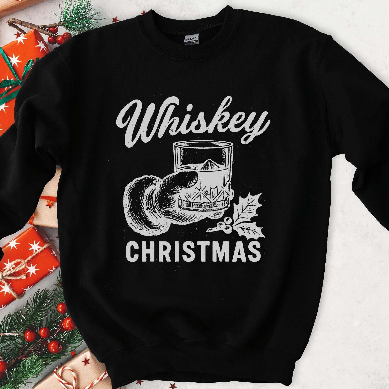 Dark sweatshirt with vintage gray art of Santa's hand holding whiskey on ice with holly, text Whiskey Christmas