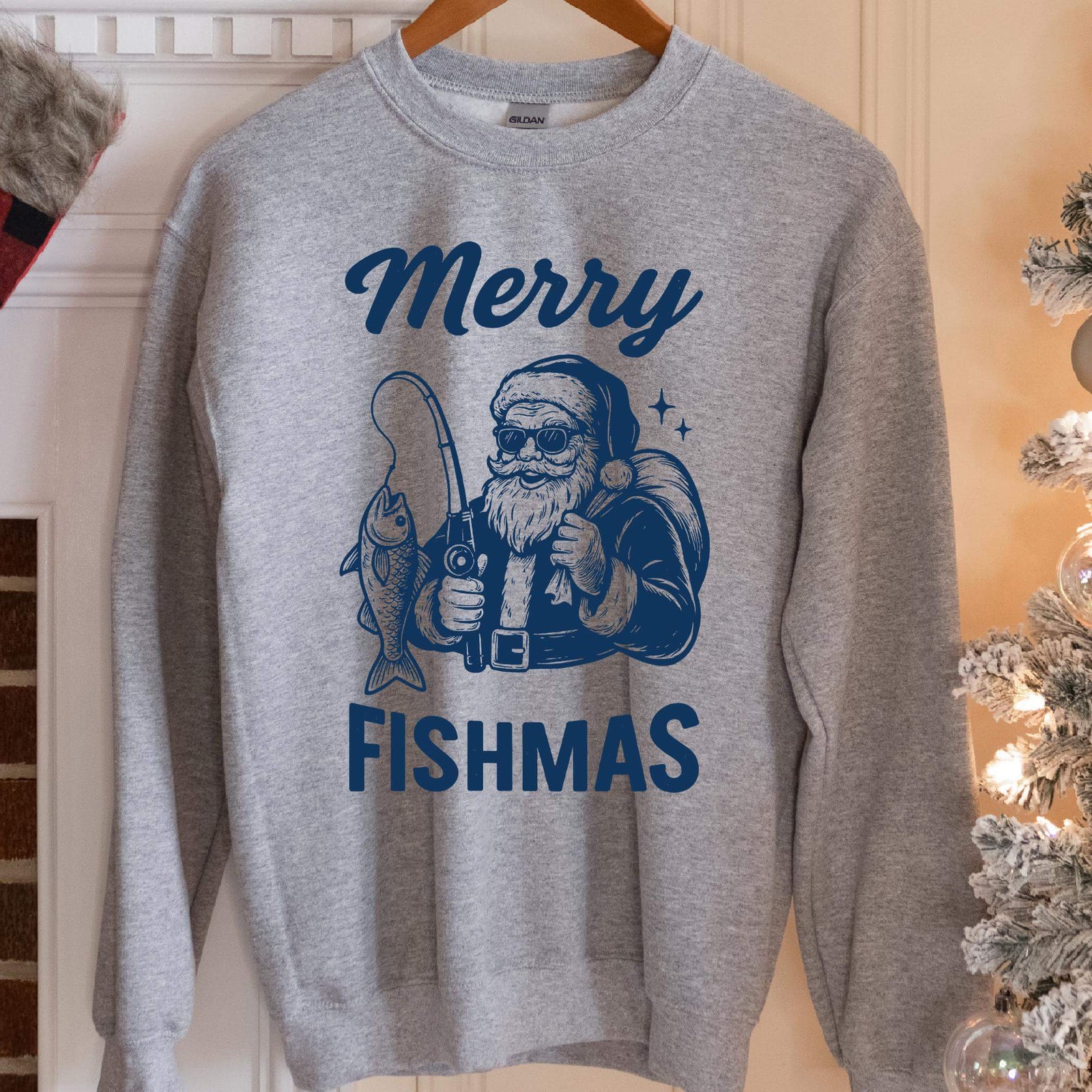 Sweatshirt with navy vintage art of Santa in sunglasses holding a fishing rod with a fish, text Merry Fishmas