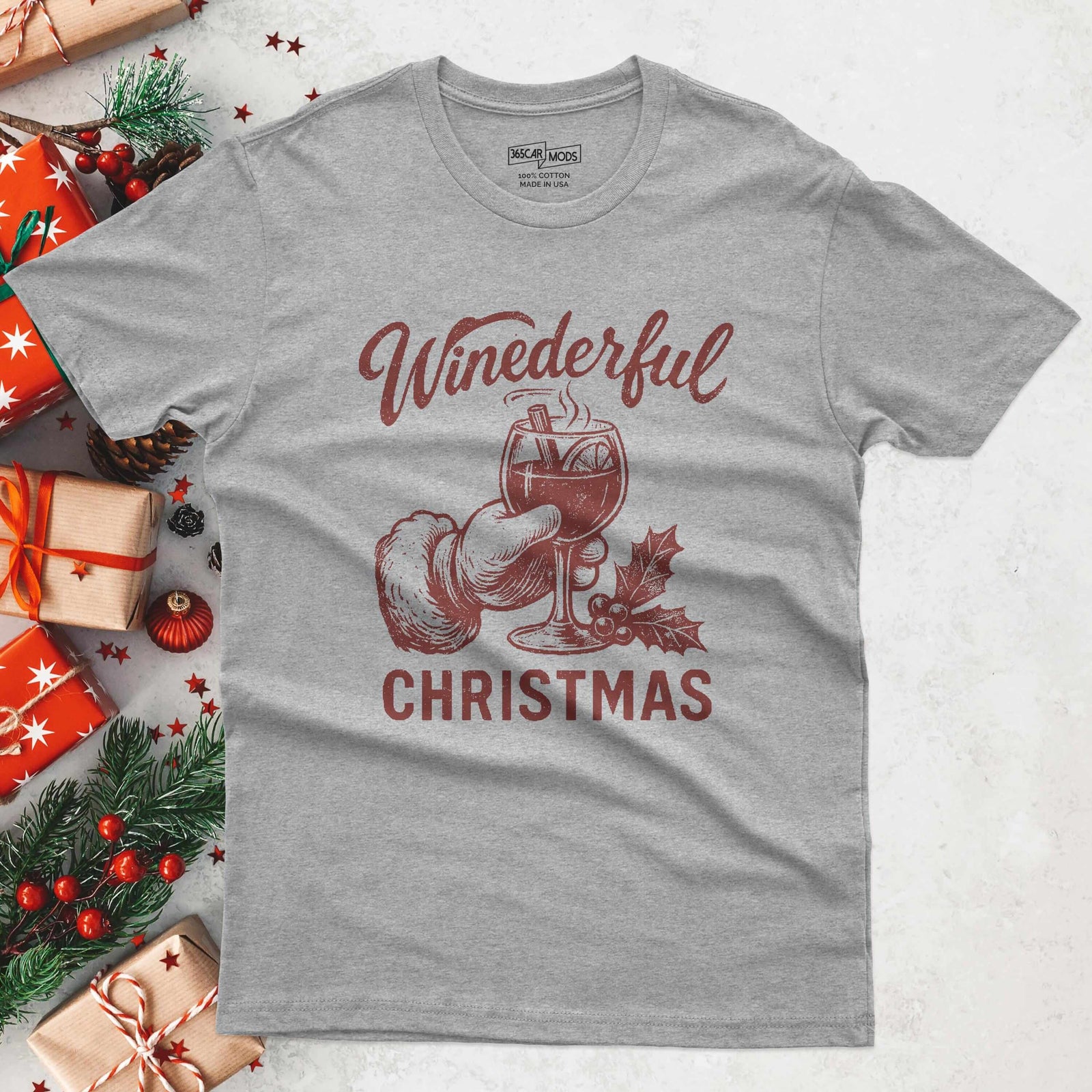 A heather gray t-shirt with a festive design. The graphic features a hand in a Santa glove holding a wine glass with the text "Winederful Christmas" in red. The shirt is made of a soft cotton blend.