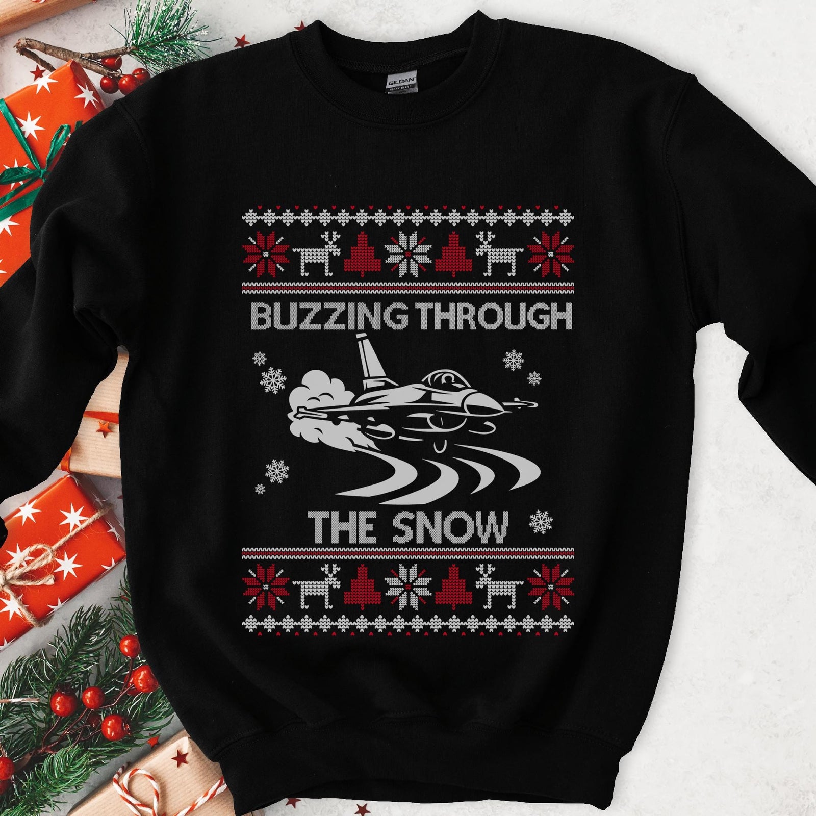 Dark Christmas sweatshirt with a fighter jet over snow trails, BUZZING THROUGH THE SNOW, red and white knit borders