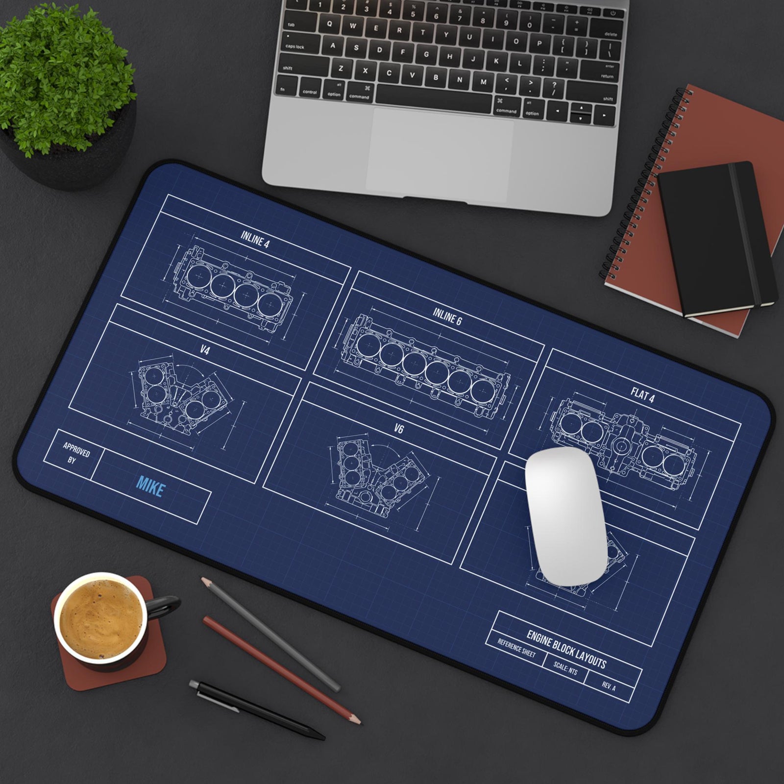 Engine block blueprint desk mat, angled top view on a dark desk
