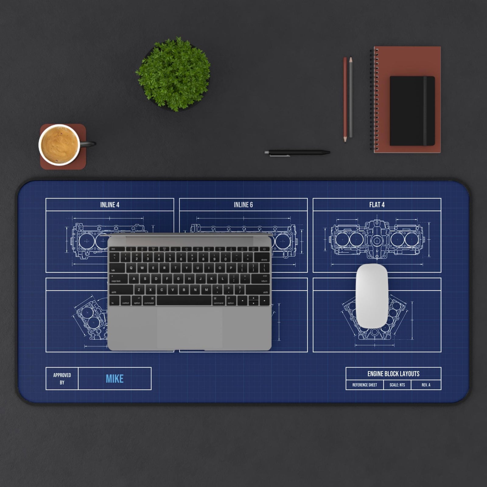 Extended engine block blueprint desk mat with laptop, coffee and notebook