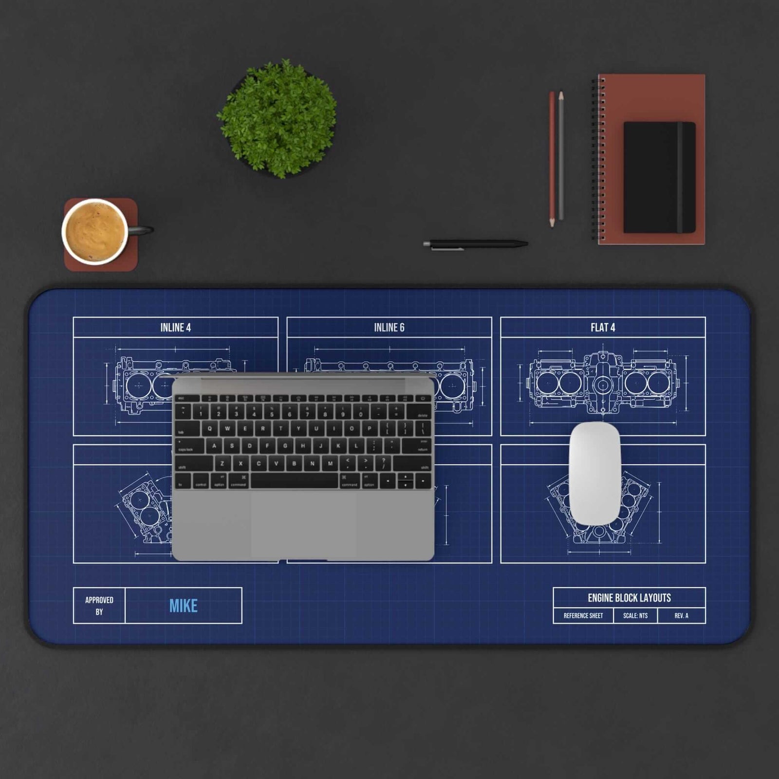 Extended engine block blueprint desk mat with laptop, coffee and notebook