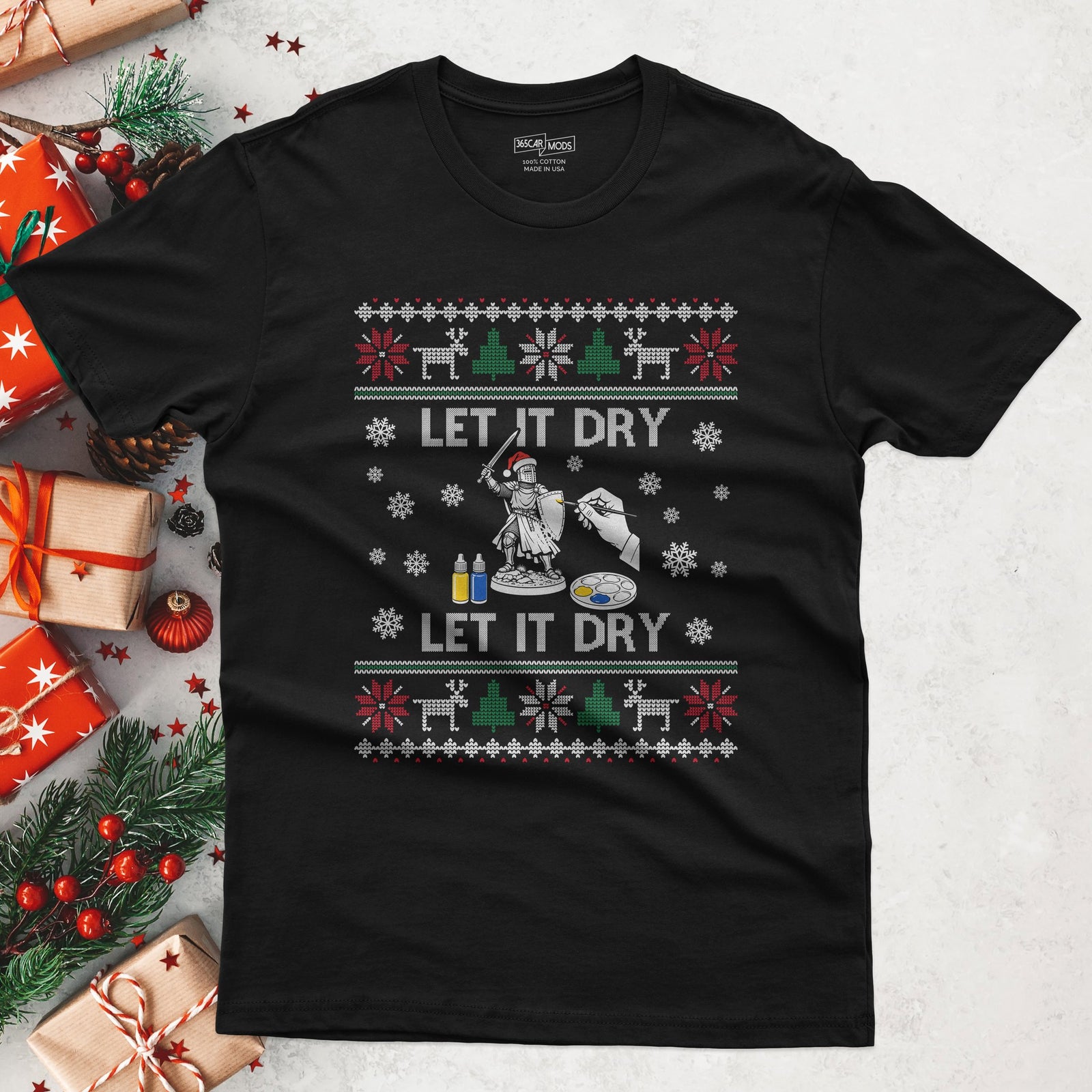 Black t-shirt with LET IT DRY, LET IT DRY in ugly sweater letters around a knight miniature in a Santa hat getting his first coat of paint
