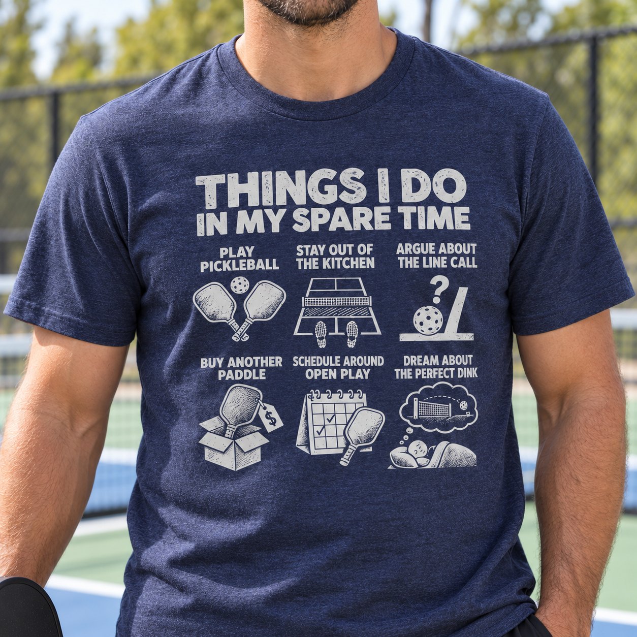 Close-up of the pickleball print on a heather navy t-shirt worn on the court