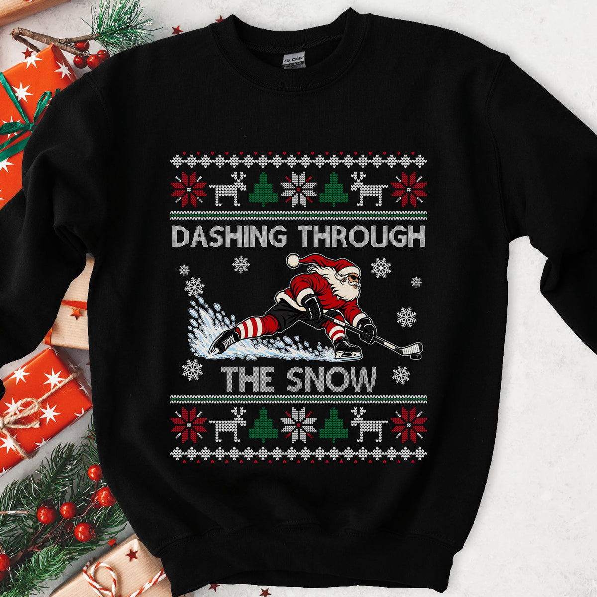 Black crewneck sweatshirt with DASHING THROUGH THE SNOW and Santa in a low hockey stance, laid flat with Christmas gifts