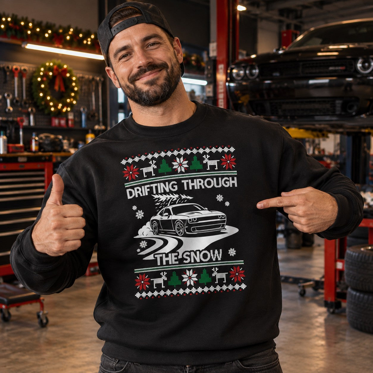 Man wearing the black Drifting Through the Snow muscle car sweatshirt in a garage