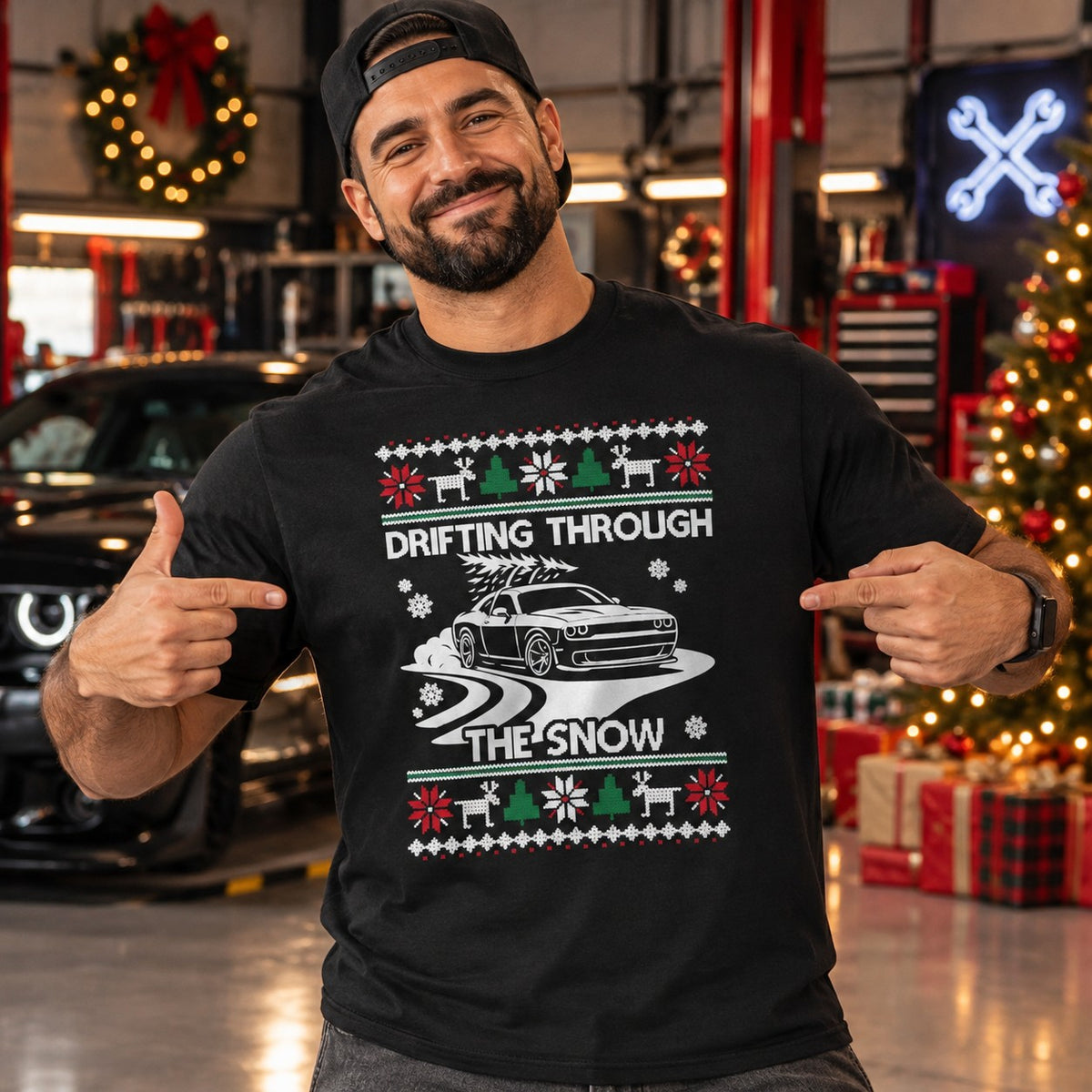 Man wearing the black Drifting Through the Snow muscle car t-shirt in a garage next to a Christmas tree