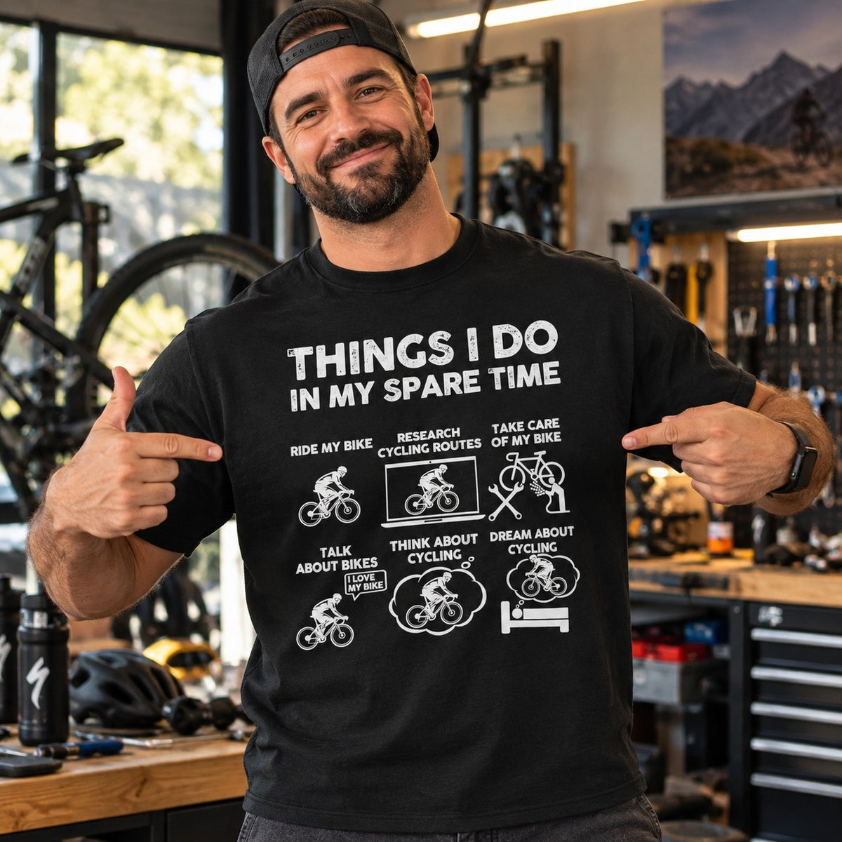 Man wearing the black Things I Do in My Spare Time cycling t-shirt in a bike workshop