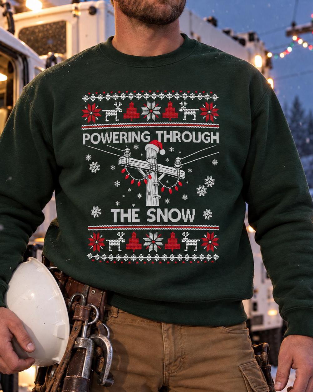 Powering Through the Snow Lineman Christmas Sweatshirt - lineman in the forest green sweatshirt with a hard hat and tool belt