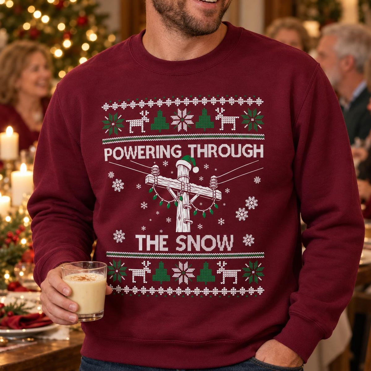 Powering Through the Snow Lineman Christmas Sweatshirt - man in the maroon sweatshirt at a Christmas party