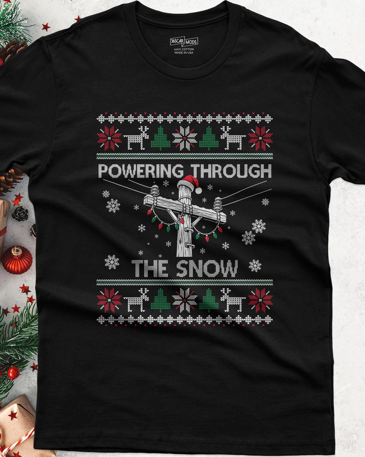 Powering Through the Snow Lineman Christmas T-Shirt - black tee, utility pole in a Santa hat wrapped in Christmas lights