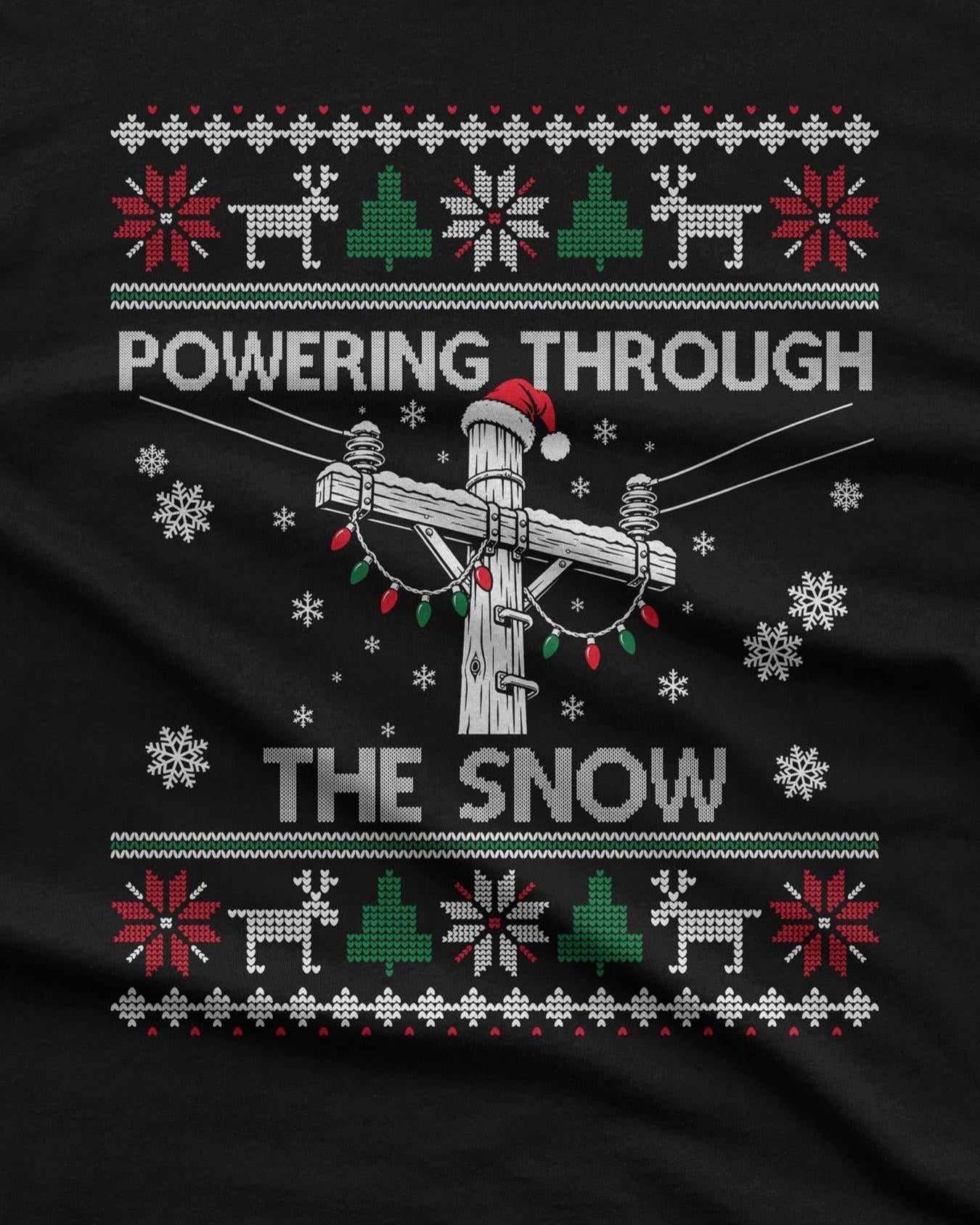 Powering Through the Snow Lineman Christmas T-Shirt - black tee, utility pole in a Santa hat wrapped in Christmas lights