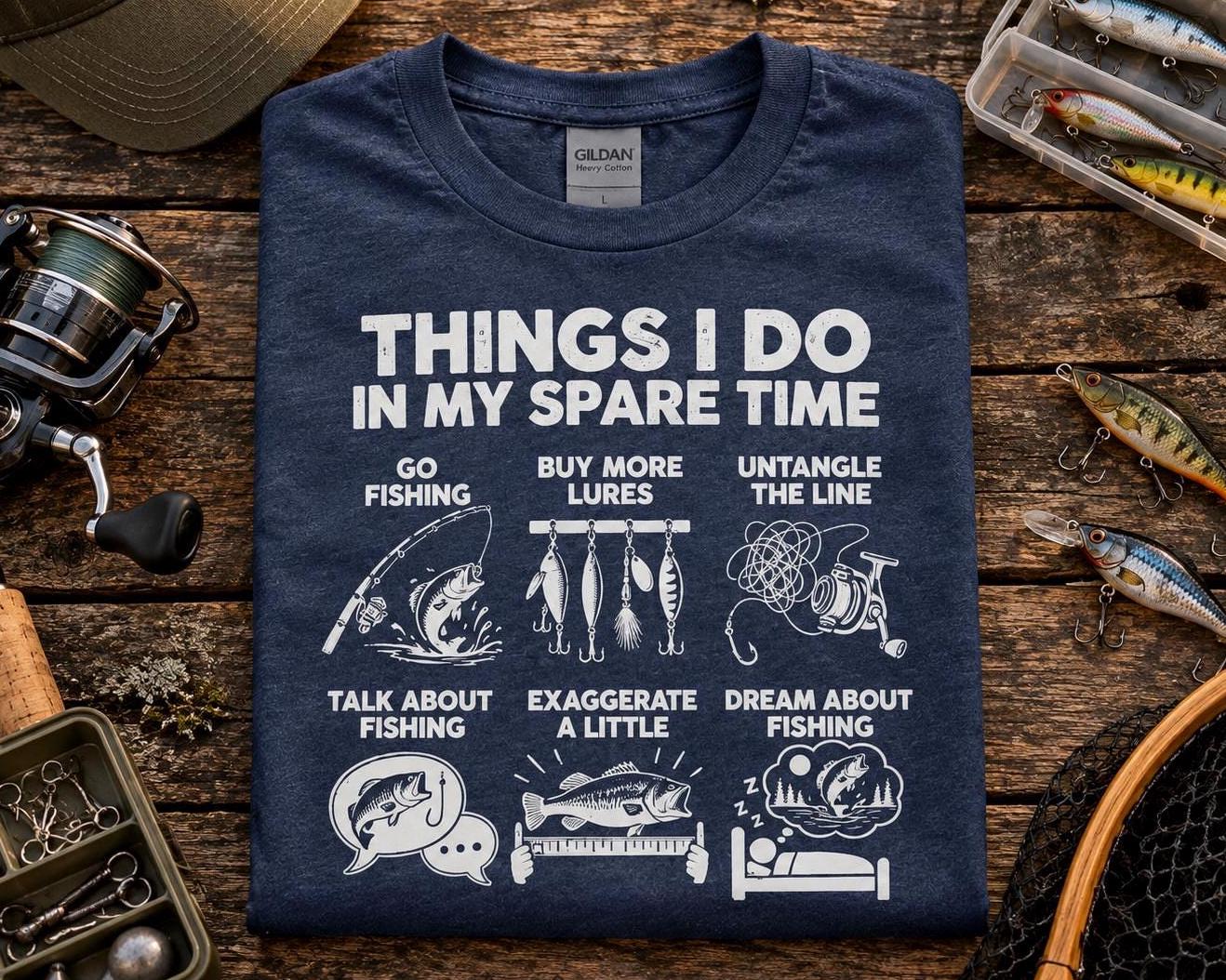 Things I Do In My Spare Time Fishing T-Shirt - heather navy t-shirt folded on a wooden table with fishing lures and a reel