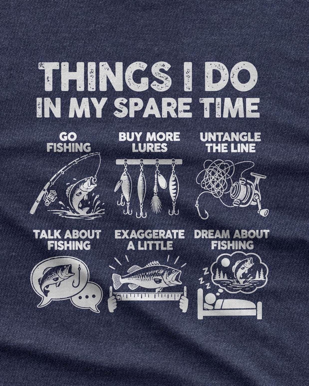 Things I Do In My Spare Time Fishing T-Shirt - heather navy t-shirt folded on a wooden table with fishing lures and a reel