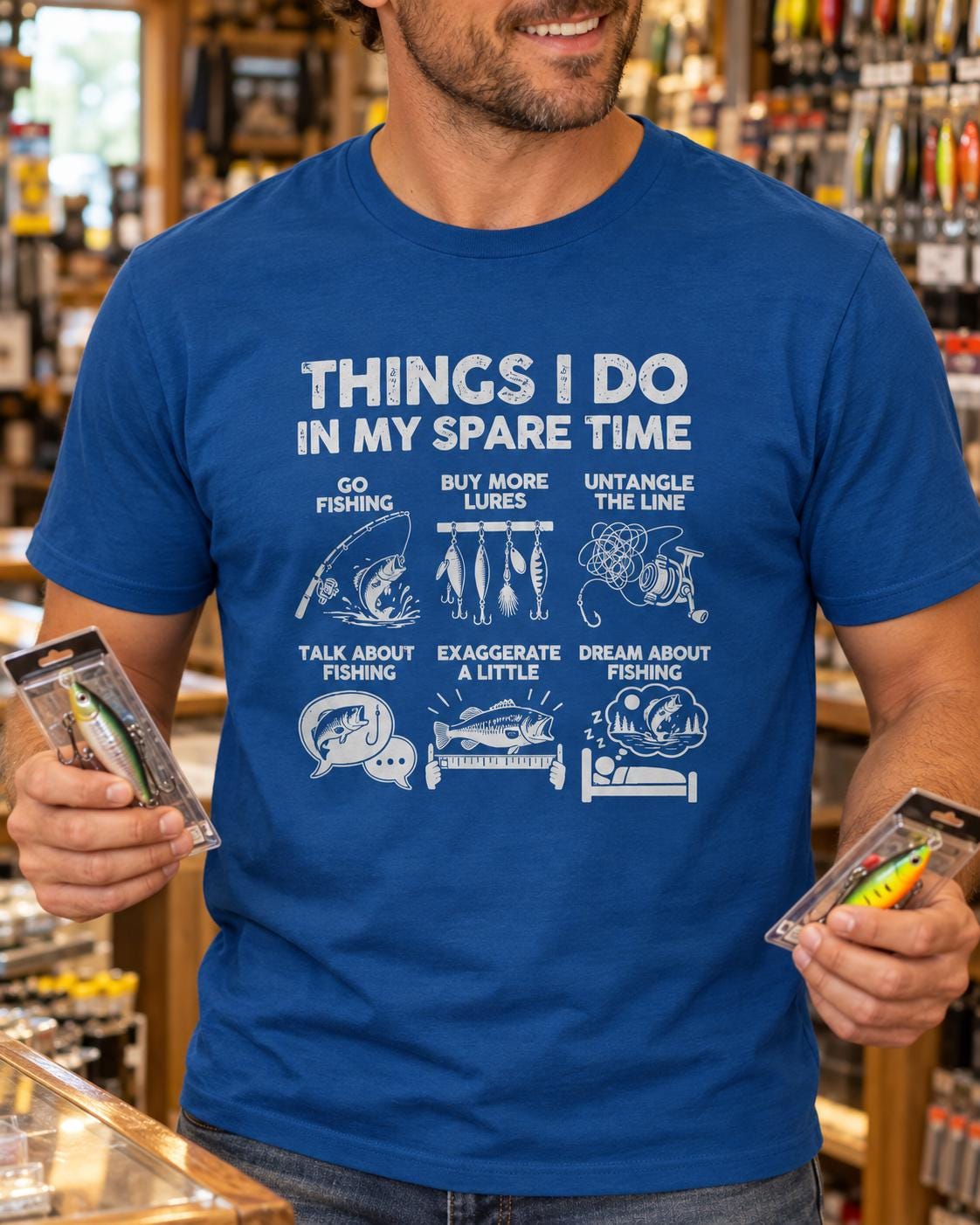 Things I Do In My Spare Time Fishing T-Shirt - man wearing the royal blue t-shirt in a tackle shop holding lures