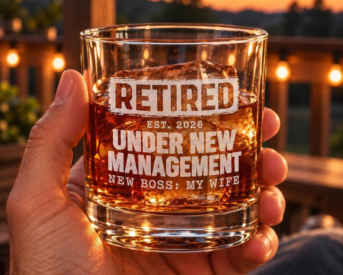Retired Under New Management Whiskey Glass - glass held in hand with whiskey at a bar
