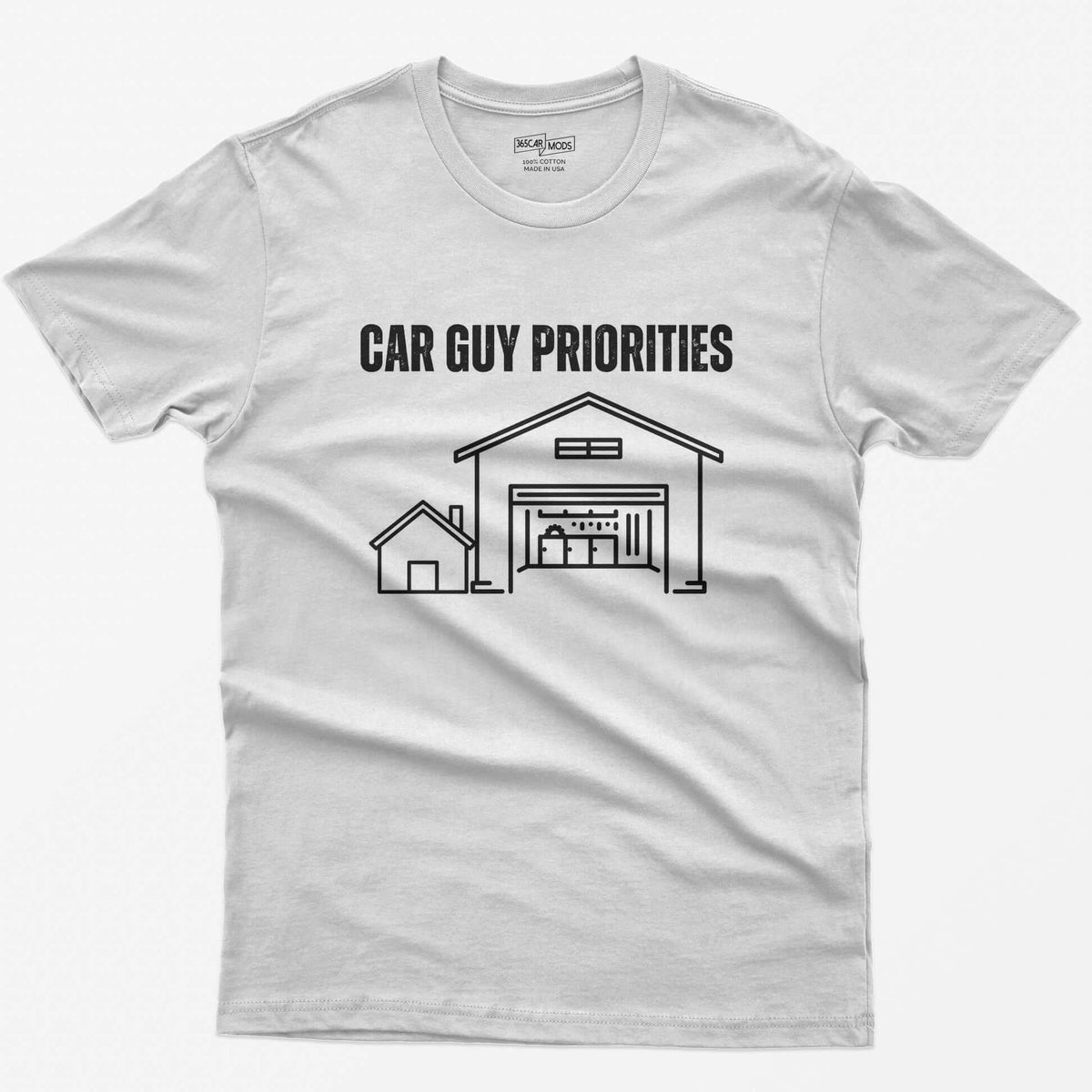 White t-shirt with Car Guy Priorities and a line drawing of a tiny house beside a huge garage with a car on a lift