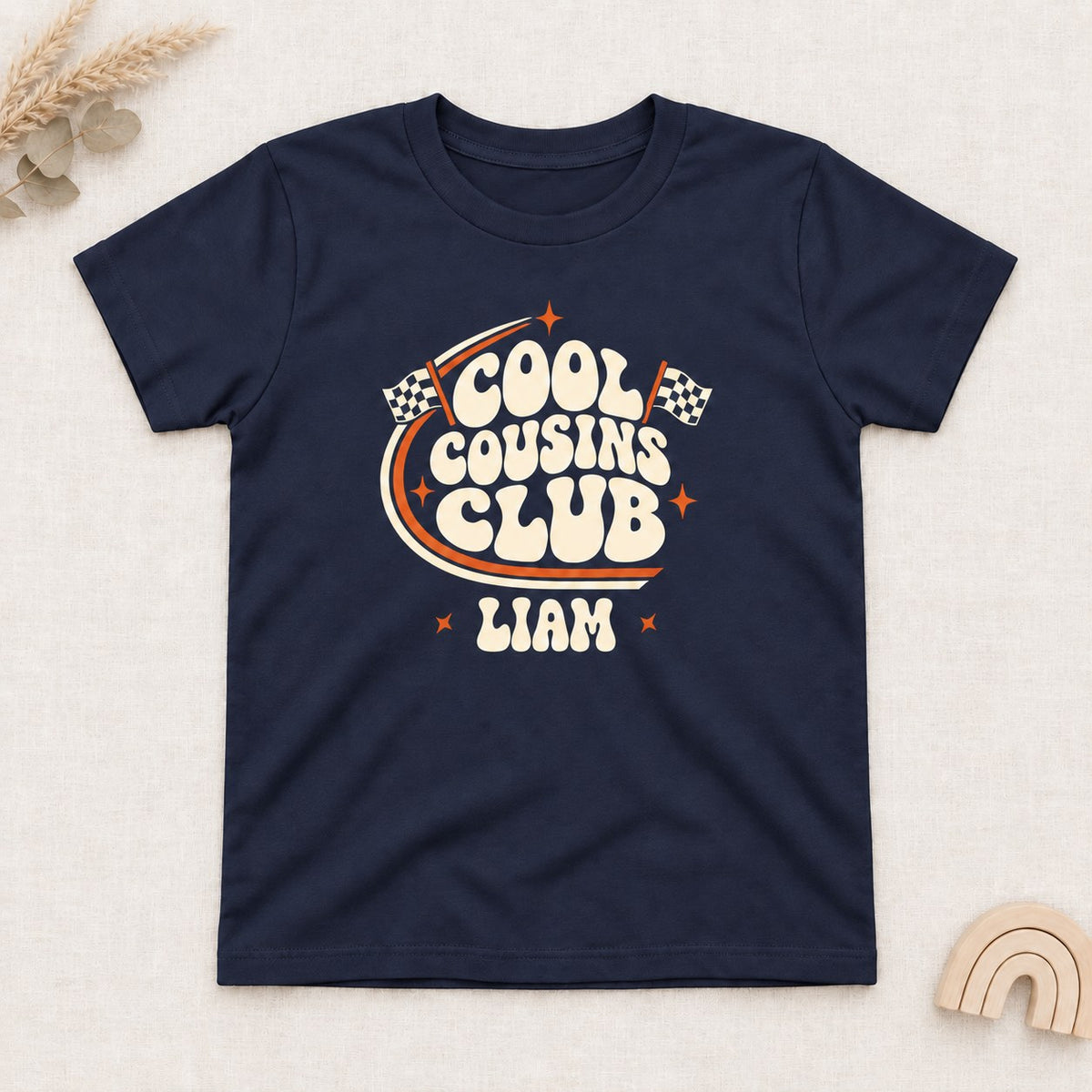 Navy t-shirt with a personalized Cool Cousins Club print with racing flags and a first name