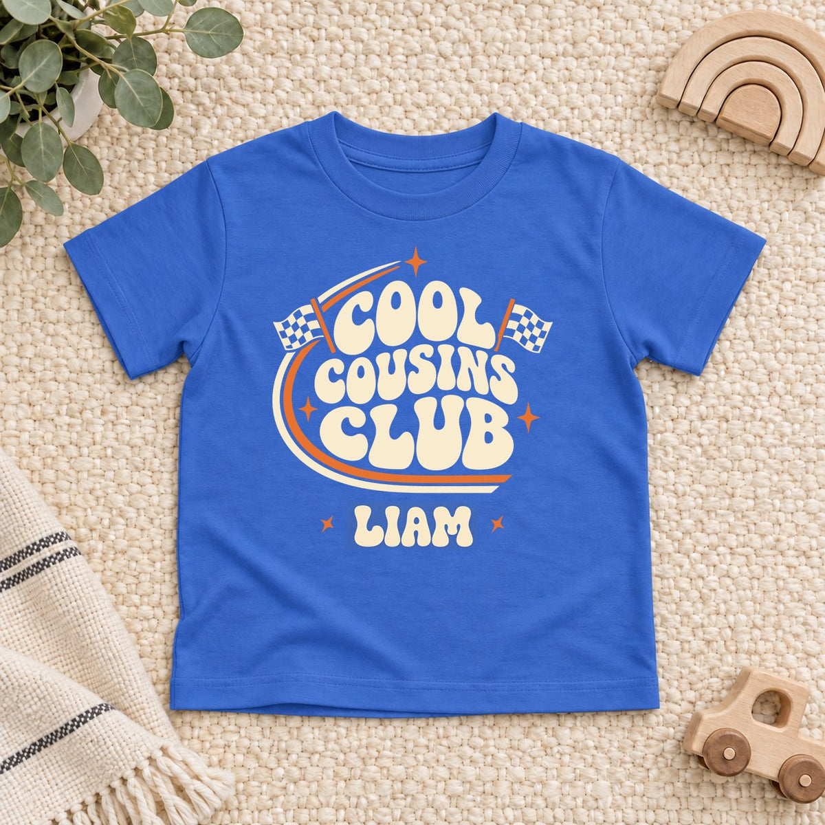 Royal blue toddler t-shirt with a personalized Cool Cousins Club print with racing flags and a first name