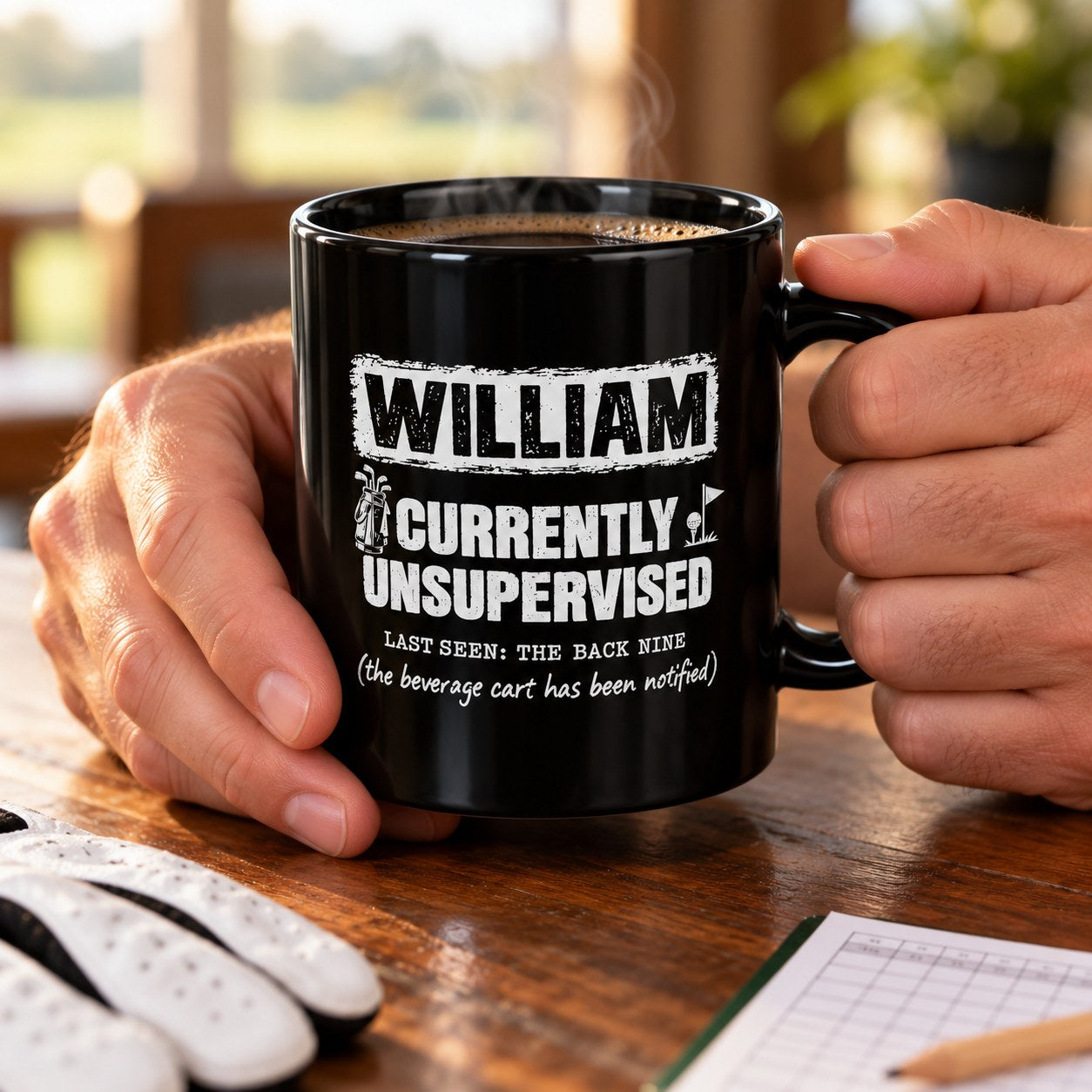 Personalized black Currently Unsupervised golf mug on a table with golf balls, tees and a glove