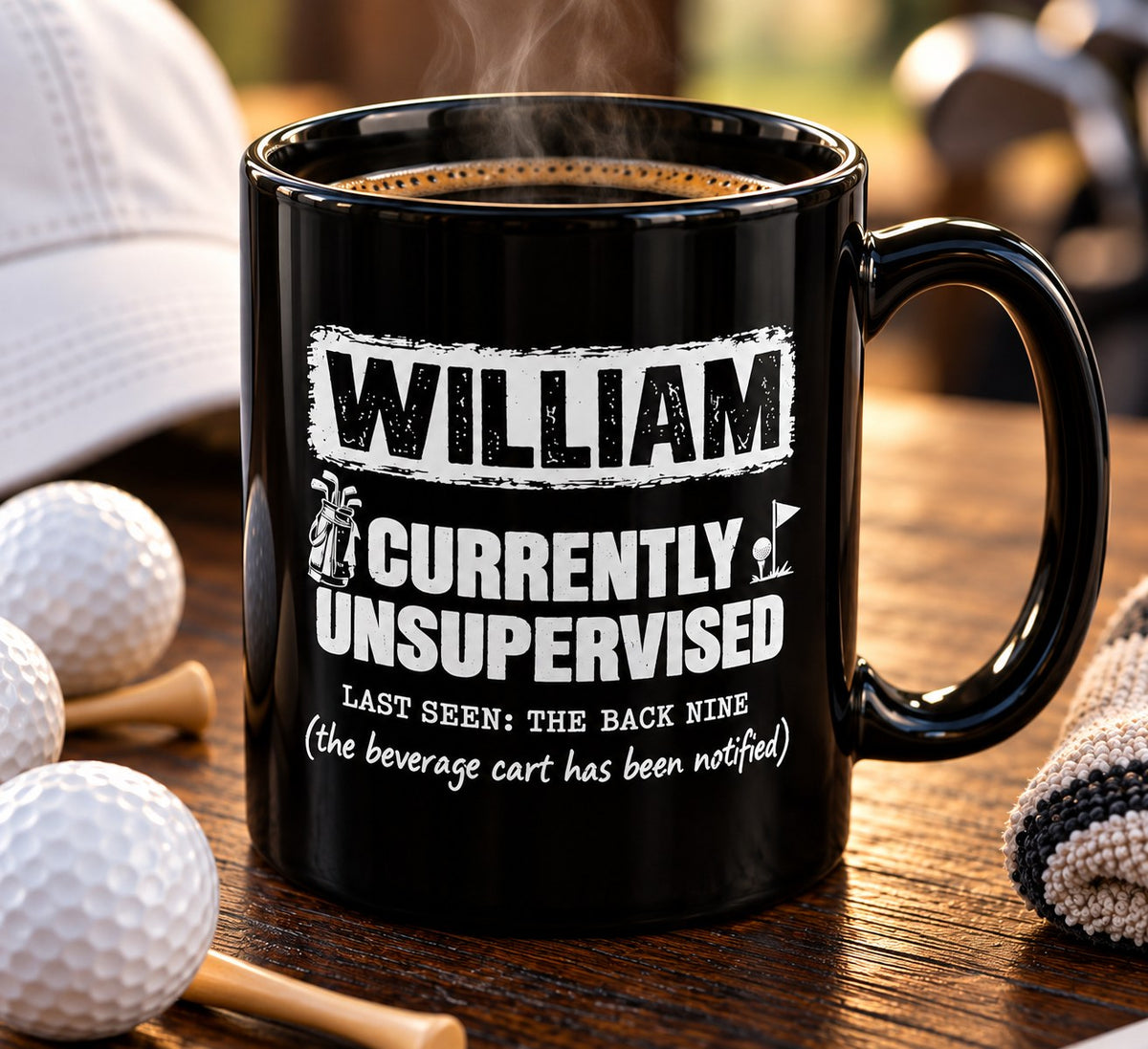 Personalized black Currently Unsupervised golf mug on a table with golf balls, tees and a glove