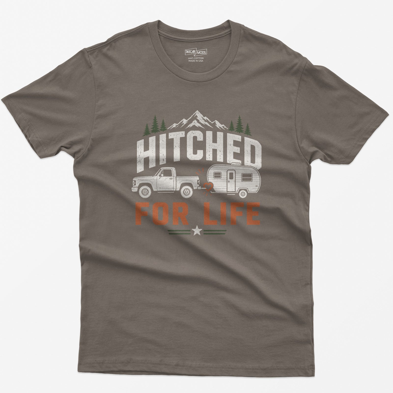Brown Savana t-shirt with Hitched For Life, a pickup towing a travel trailer joined by a heart-shaped hitch, mountains and pines
