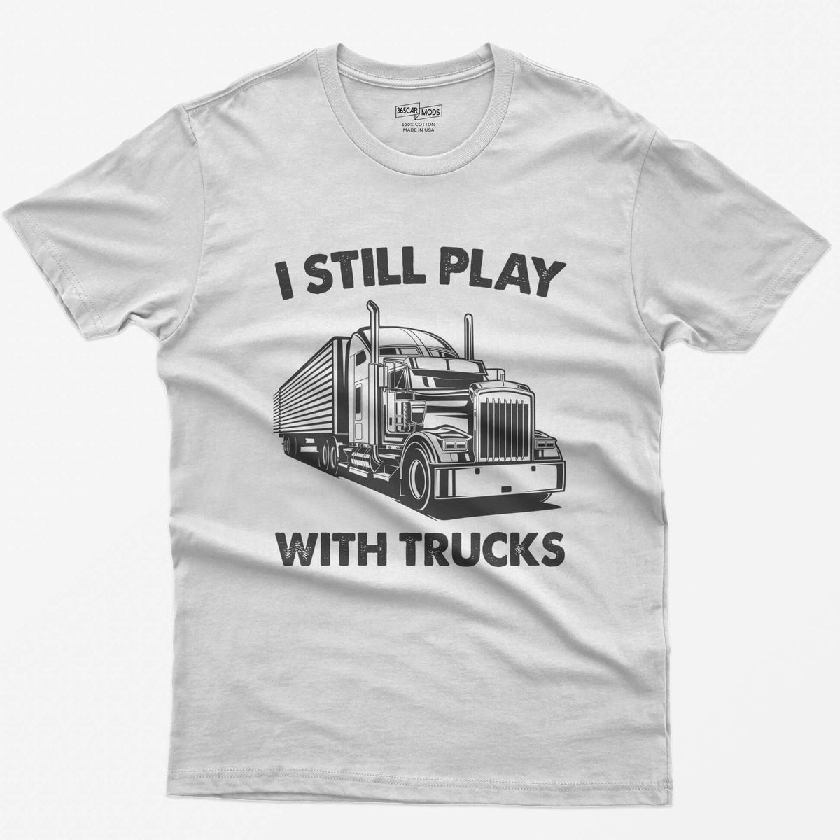 White t-shirt with I Still Play With Trucks text and a white line drawing of a long-nose semi truck with trailer