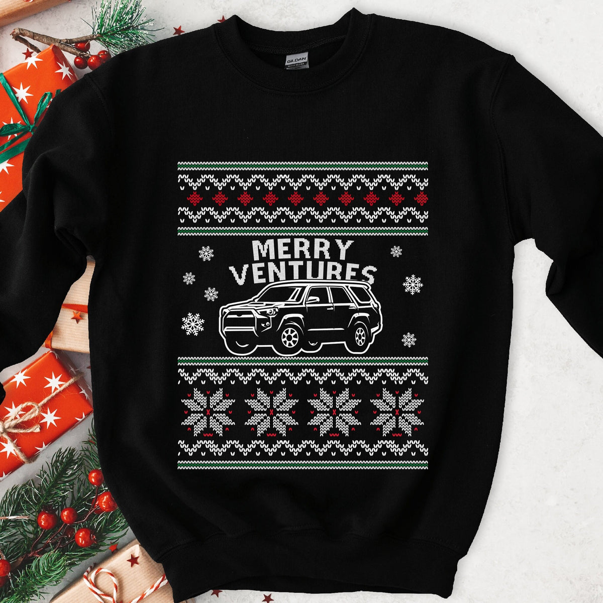 Dark sweatshirt with ugly sweater knit borders, MERRY VENTURES text and a white off-road SUV among snowflakes