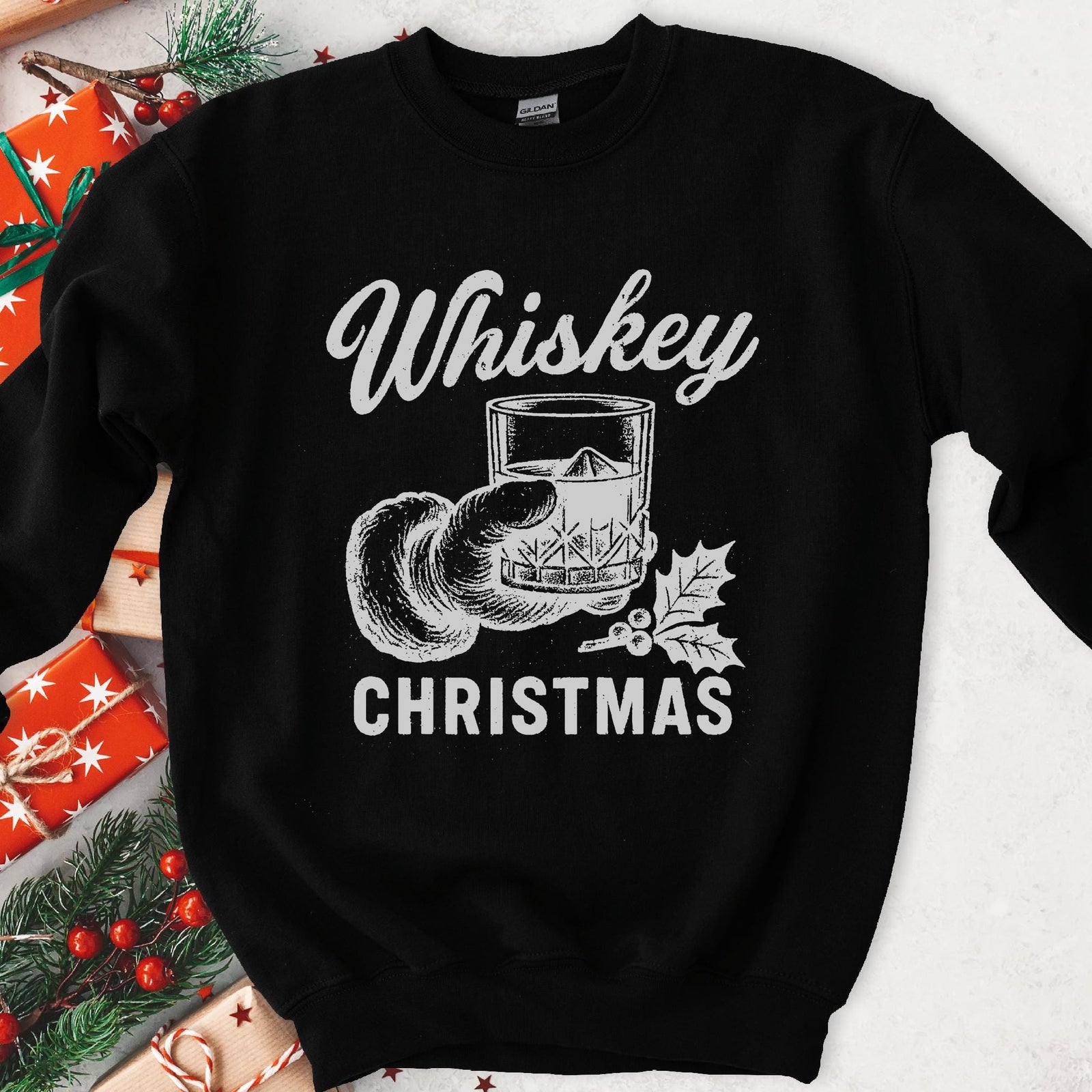 Dark sweatshirt with vintage gray art of Santa's hand holding whiskey on ice with holly, text Whiskey Christmas