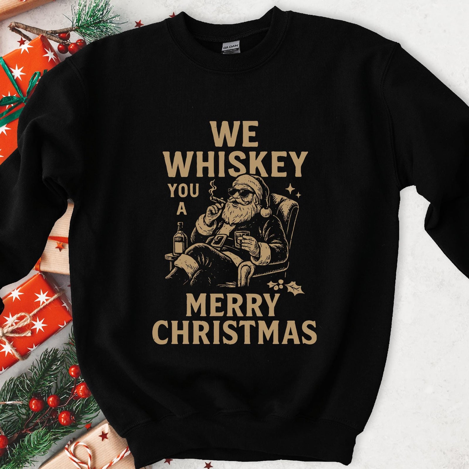 Dark sweatshirt, tan art of Santa in sunglasses with a cigar and whiskey, text We Whiskey You a Merry Christmas