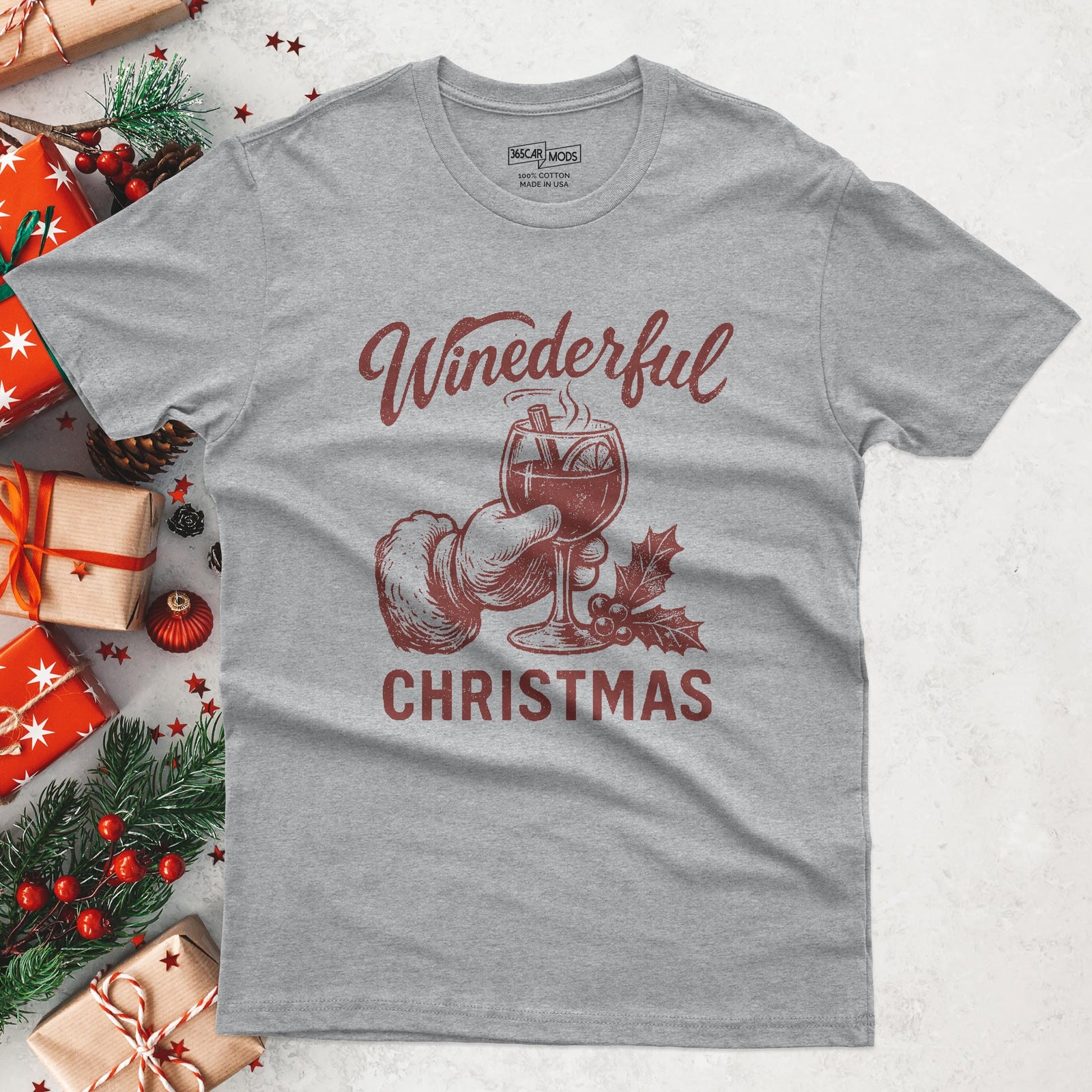 A heather gray t-shirt with a festive design. The graphic features a hand in a Santa glove holding a wine glass with the text "Winederful Christmas" in red. The shirt is made of a soft cotton blend.