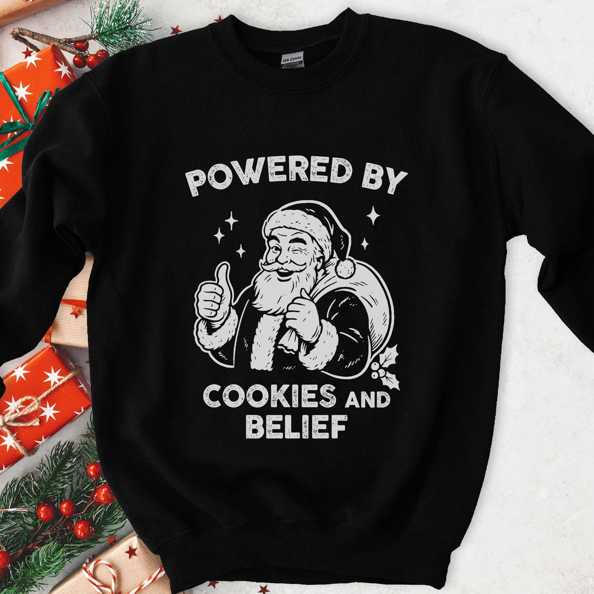 Dark sweatshirt with vintage gray art of a winking Santa giving a thumbs up, text Powered By Cookies and Belief