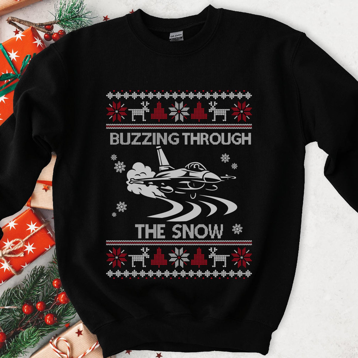 Dark Christmas sweatshirt with a fighter jet over snow trails, BUZZING THROUGH THE SNOW, red and white knit borders