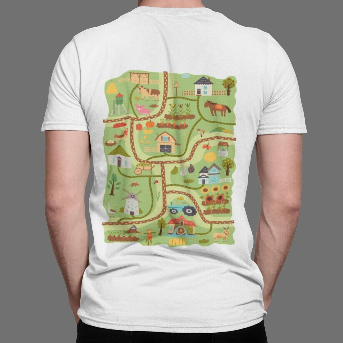 Back of a white t-shirt with a farm play road map: barn, animals, tractor, windmill and sunflowers on winding roads.