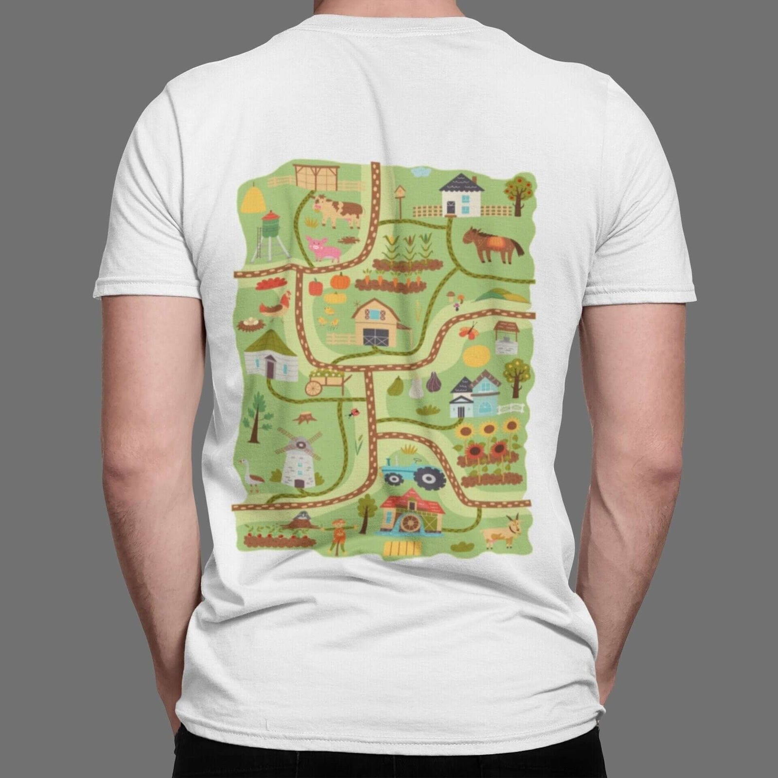 Back of a white t-shirt with a farm play road map: barn, animals, tractor, windmill and sunflowers on winding roads.