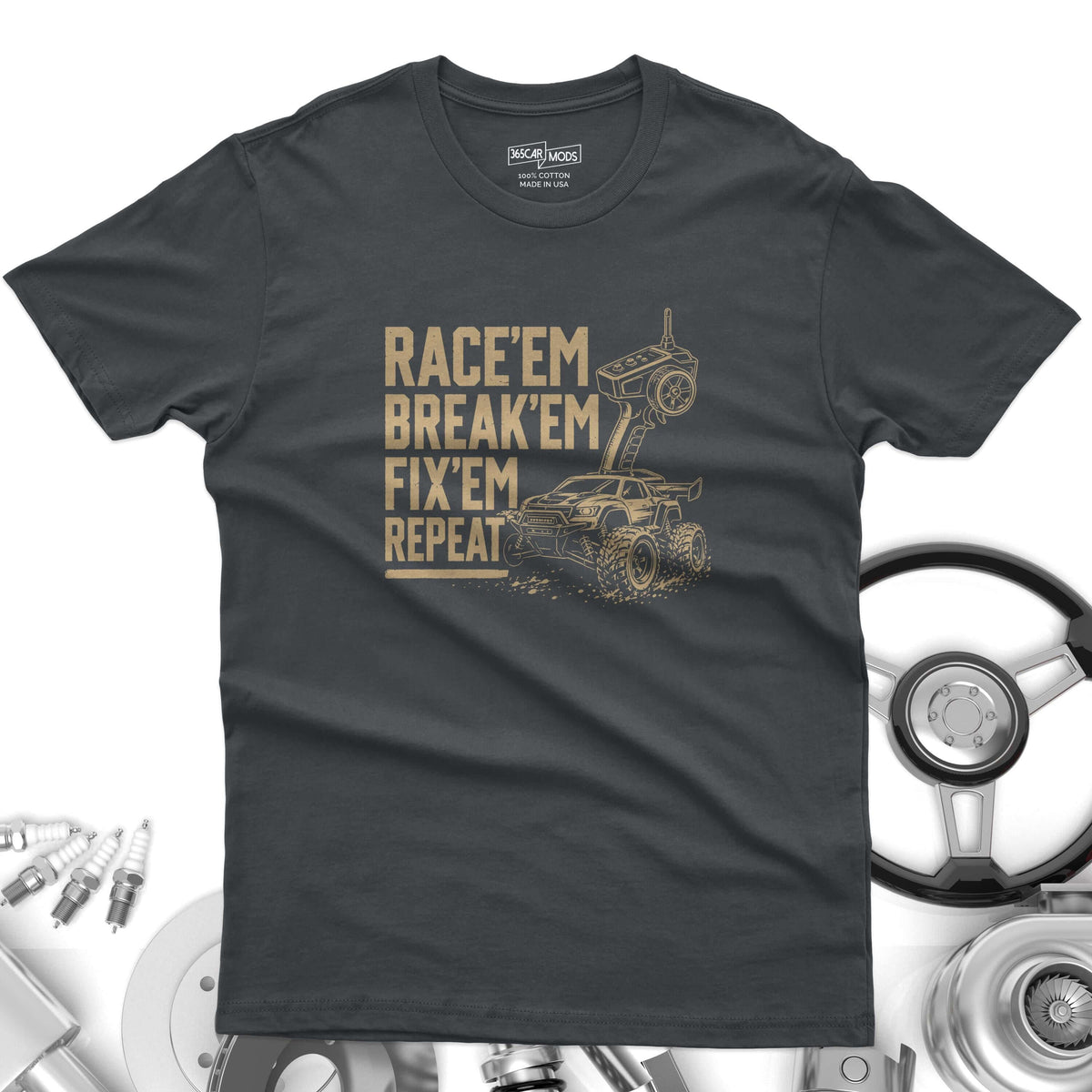 A charcoal gray short-sleeve t-shirt featuring a tan graphic of a remote-controlled truck and controller. The text reads: RACE'EM BREAK'EM FIX'EM REPEAT.