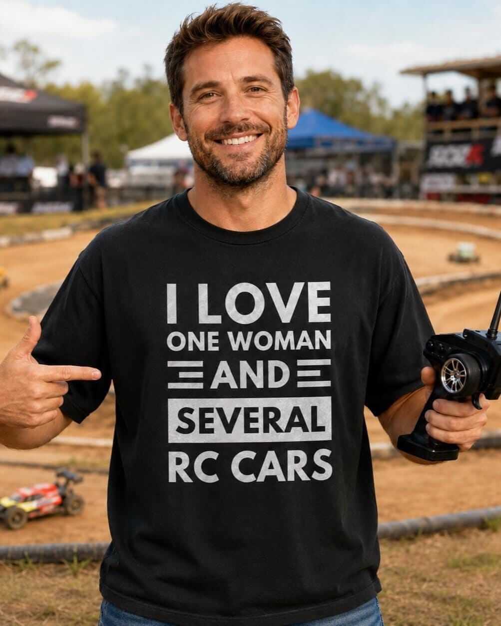 A black short-sleeved t-shirt featuring white text that reads I LOVE ONE WOMAN AND SEVERAL RC CARS.