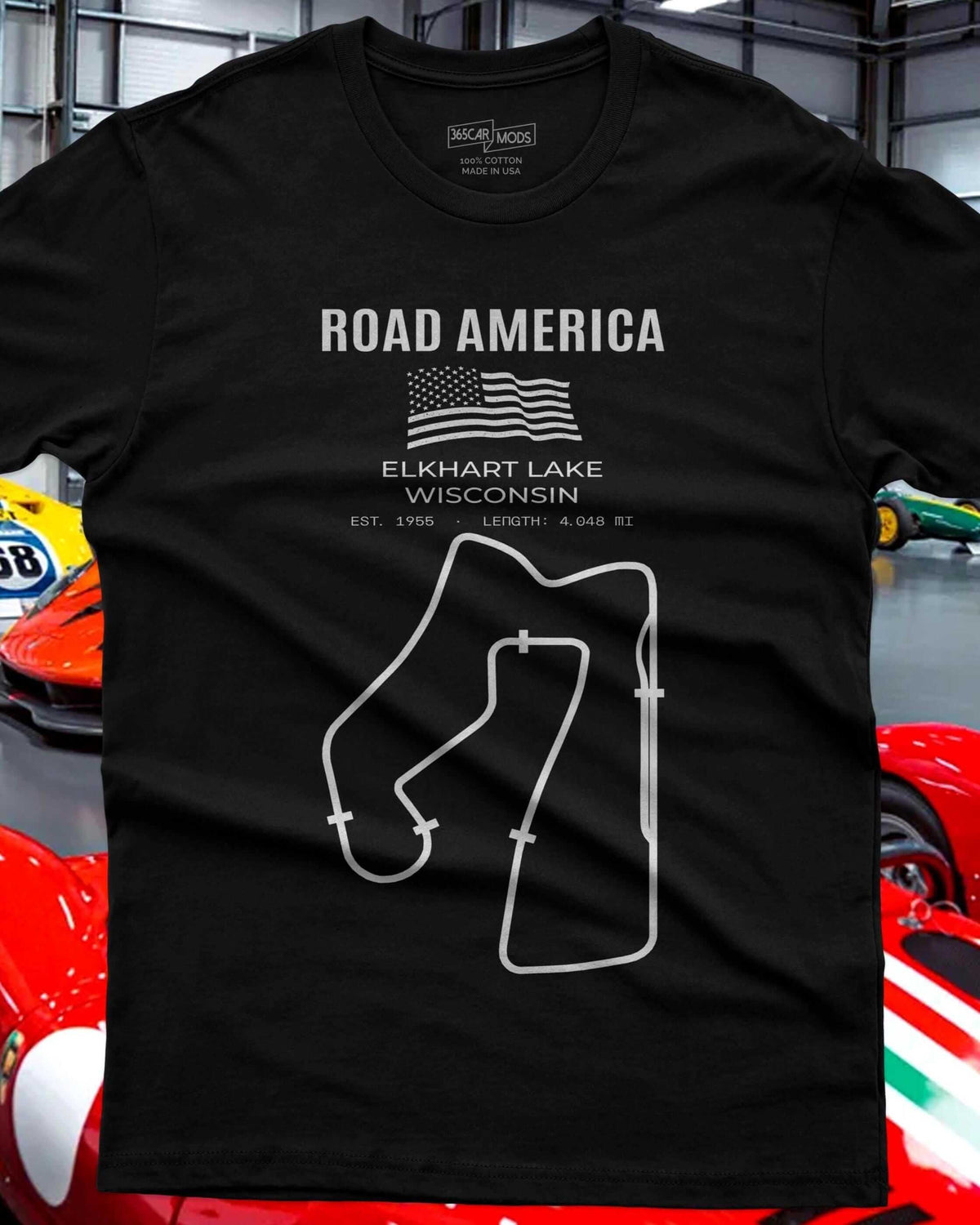 A black t-shirt with a white graphic of the Road America race track layout and the text ROAD AMERICA, ELKHART LAKE WISCONSIN.