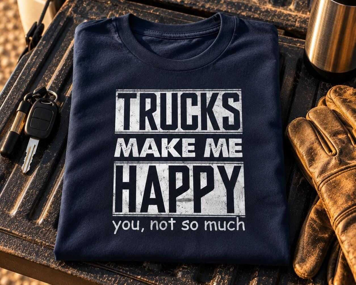 Folded navy blue trucks make me happy t-shirt on a pickup truck tailgate next to keys, work gloves and a steel coffee thermos