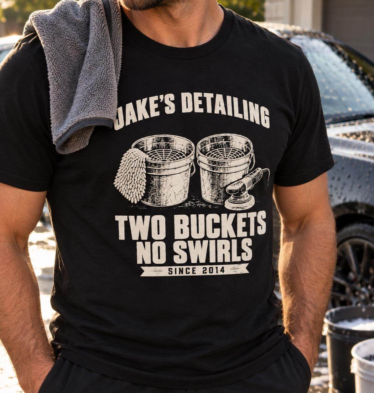 Man wearing the black personalized Two Buckets No Swirls t-shirt beside a freshly washed car