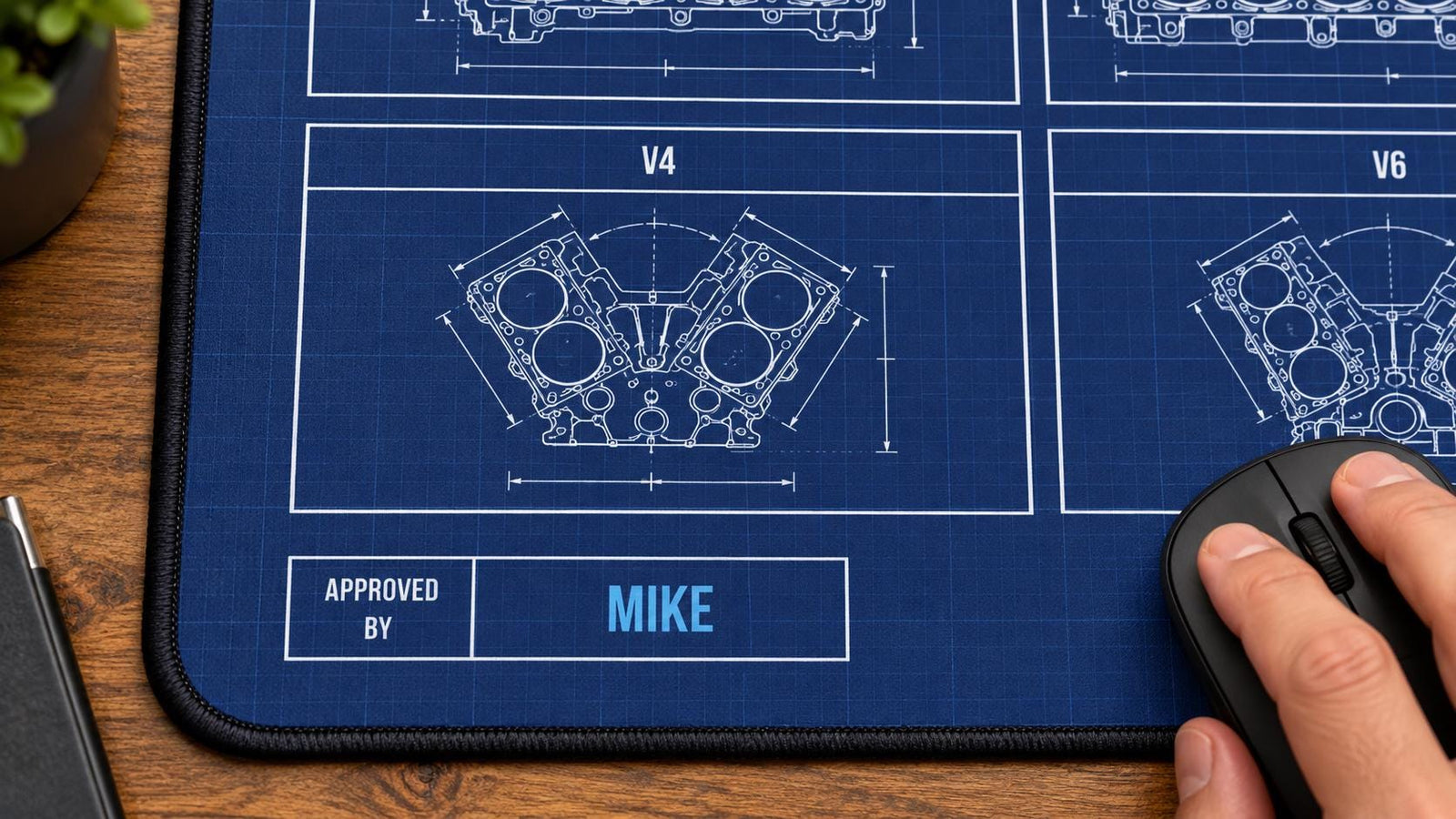 Hand using a mouse on the engine blueprint desk mat with MIKE in the Approved By box
