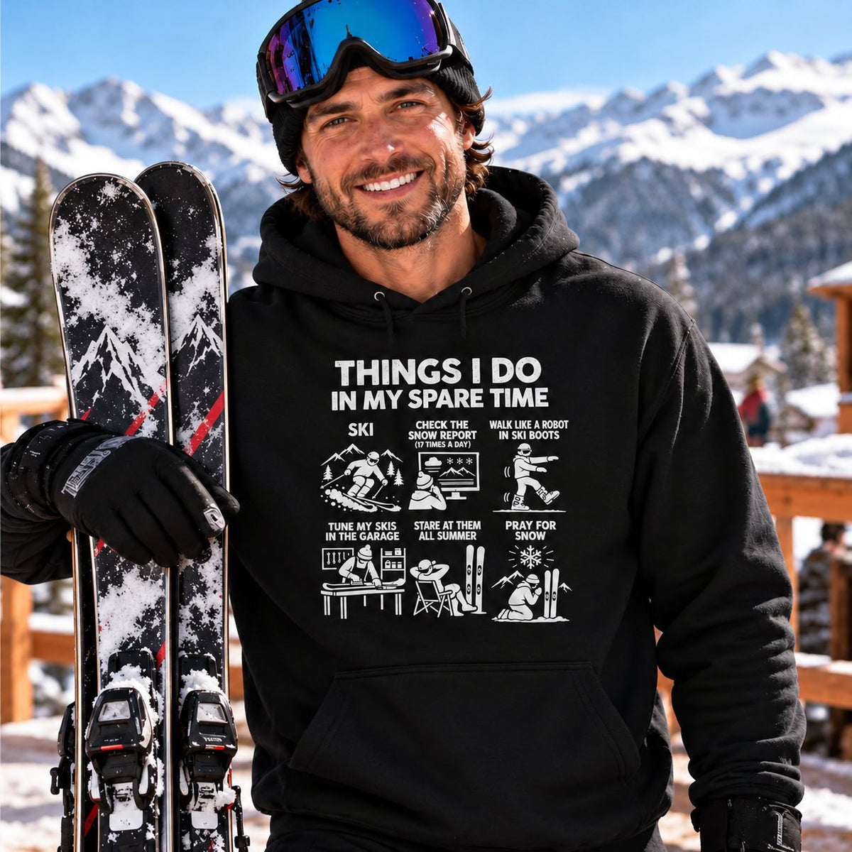 Skier in the black Things I Do In My Spare Time ski hoodie holding his skis at a mountain lodge