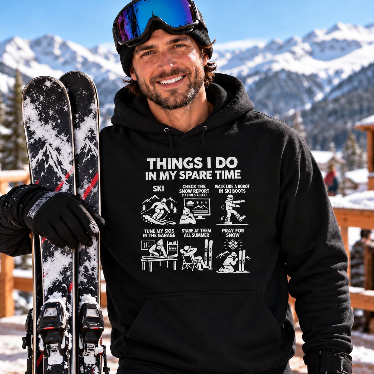 Skier in the black Things I Do In My Spare Time ski hoodie holding his skis at a mountain lodge