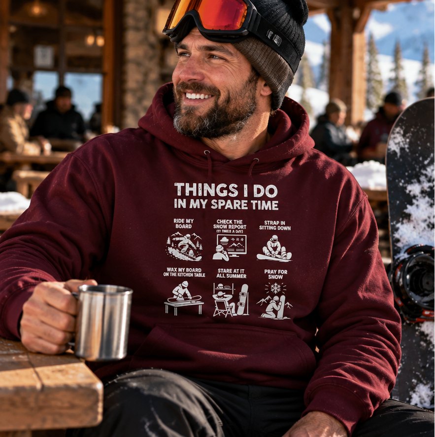 Man in the maroon snowboard hoodie with a mug at the ski lodge