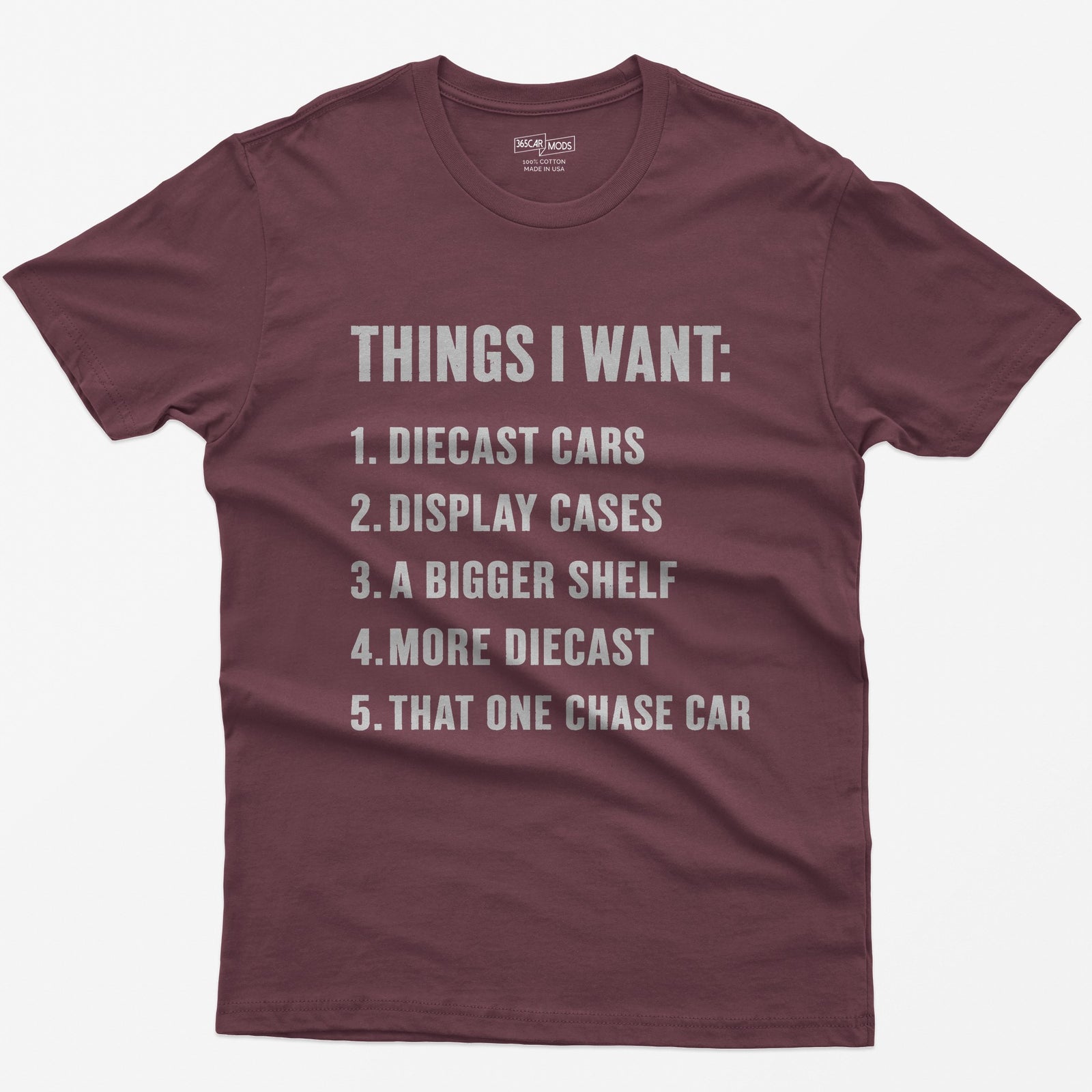 Maroon t-shirt with white block text Things I Want list: diecast cars, display cases, a bigger shelf, that one chase car
