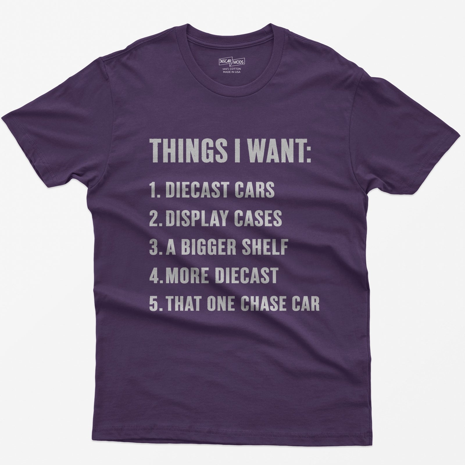 Purple t-shirt with white block text Things I Want list: diecast cars, display cases, a bigger shelf, that one chase car